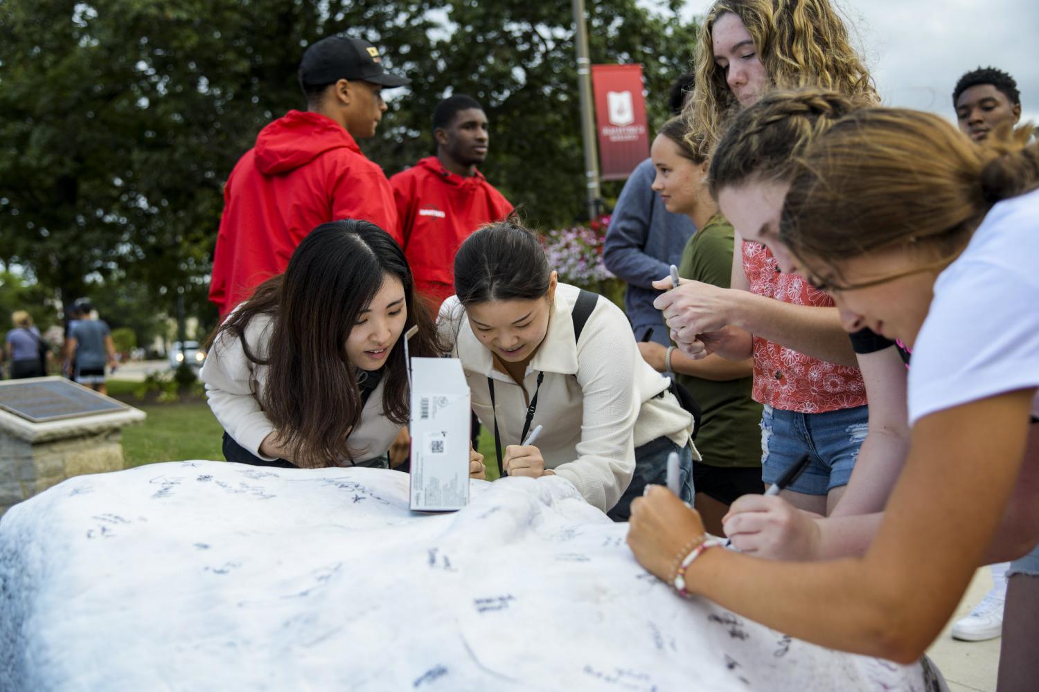 今天, students sign their names on Kissing Rock when they first arrive on campus, and four years...